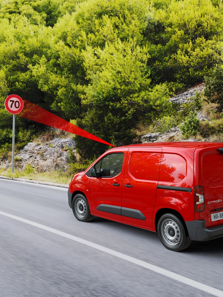 Berlingo Van rijdend op een landelijke weg, met verkeersbordherkenning die de geldende snelheidslimiet toont.