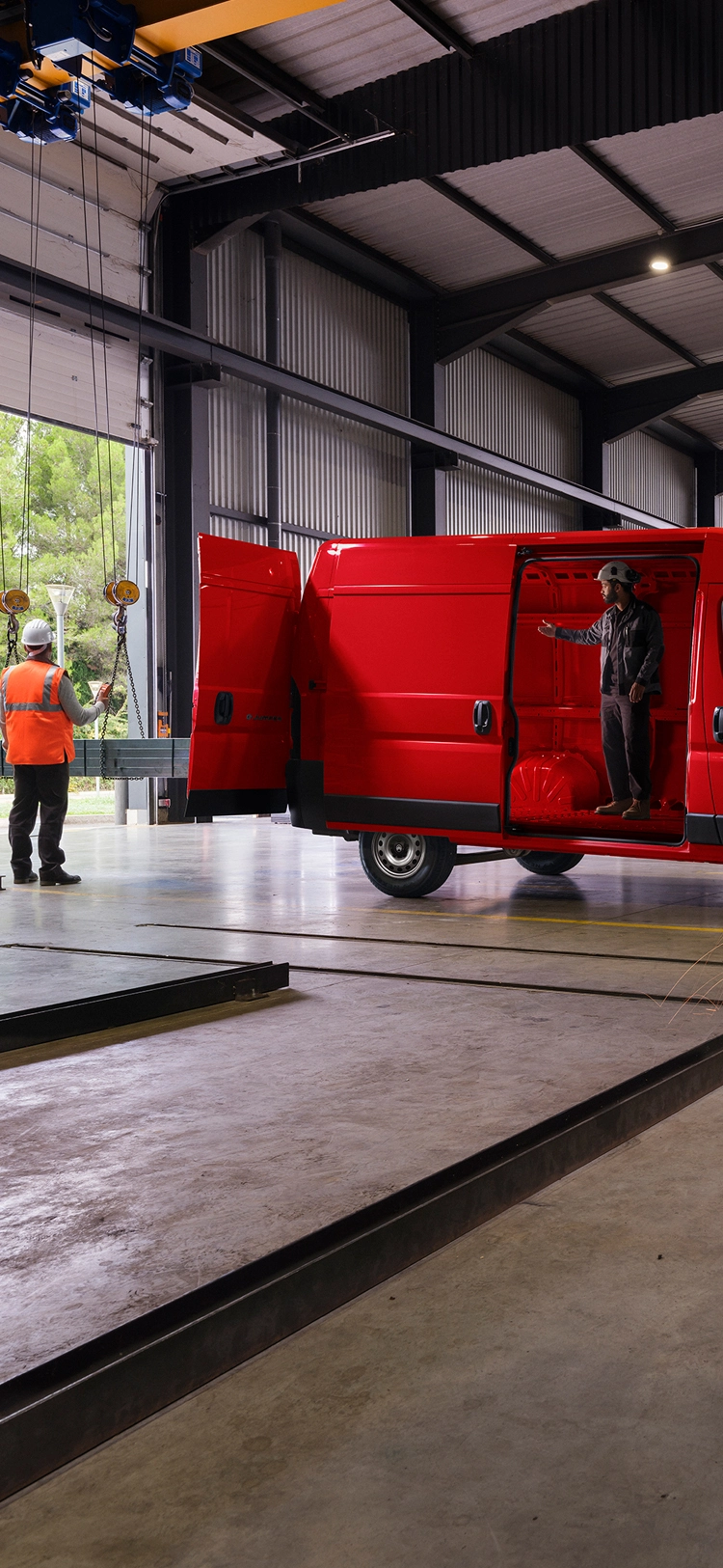 Zijaanzicht van een rode Citroën Jumper in een werkplaatsomgeving, waarbij het robuuste exterieur en de geschiktheid voor professioneel gebruik worden benadrukt.