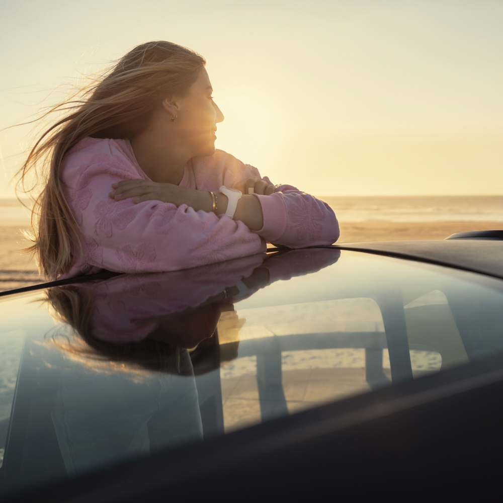 Bovenaanzicht in lifestyle‑setting van de Citroën Ami x Rip Curl bij zonsondergang, als korte ontsnapping in de stad.