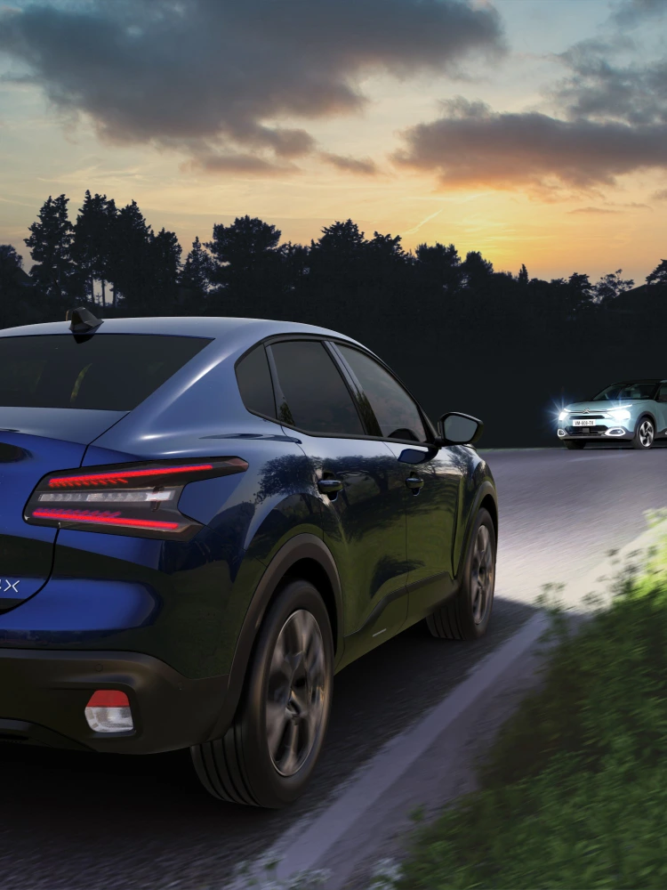 De Citroën ë‑C4 X rijdend in het donker met High Beam Assist die de weg veilig verlicht.