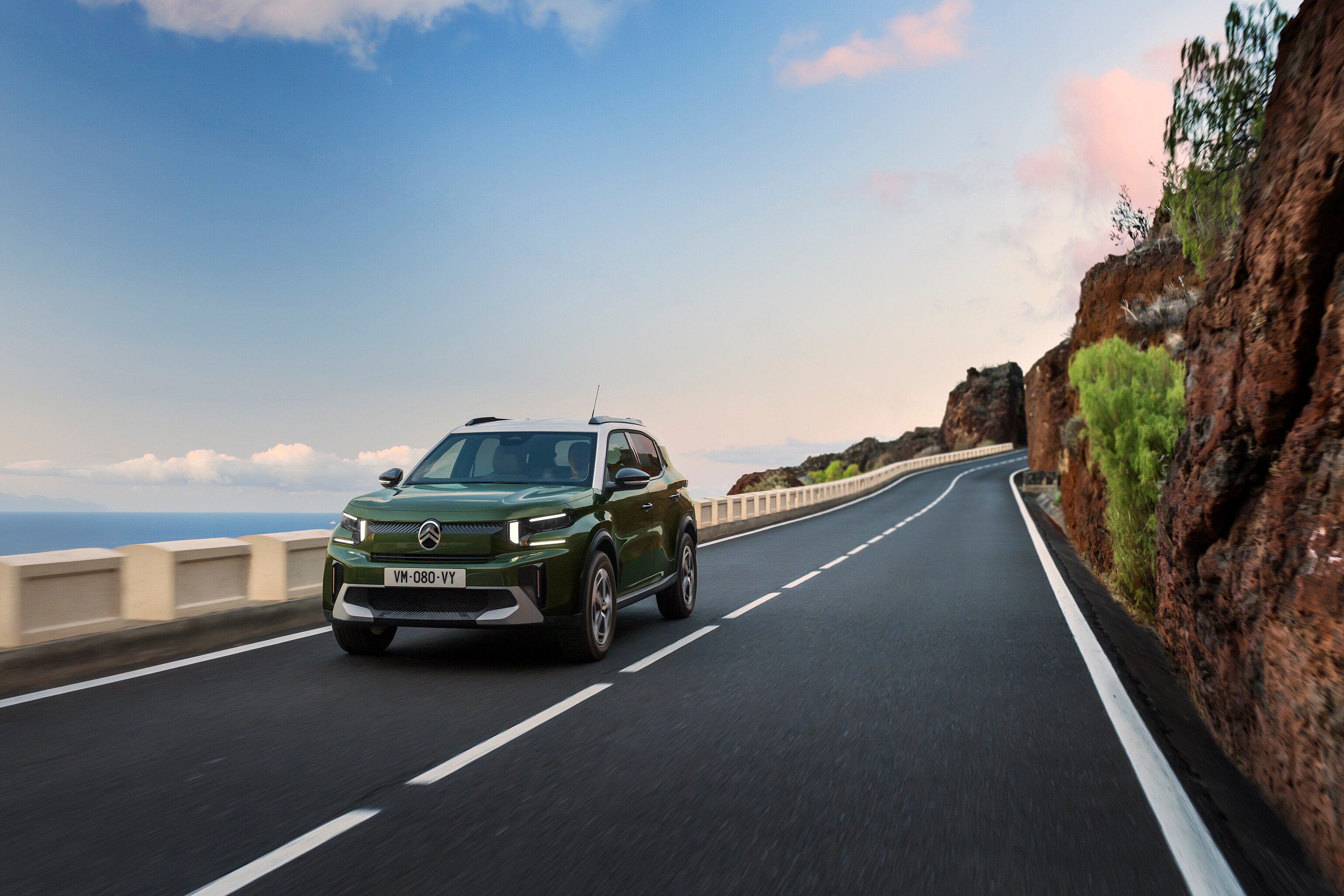 Driekwart vooraanzicht rijdend van de Citroën C3 Aircross SUV op een schilderachtige weg, met wendbare, zelfverzekerde en betaalbare dagelijkse mobiliteit.