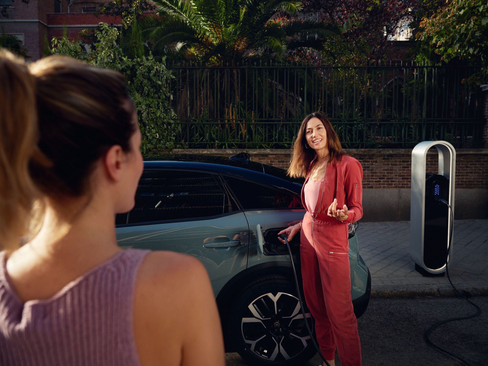 Schuin achteraanzicht van de C4 Electric met moeiteloos laden, efficiëntie, comfort en design voor een warm premium moment in de stad.