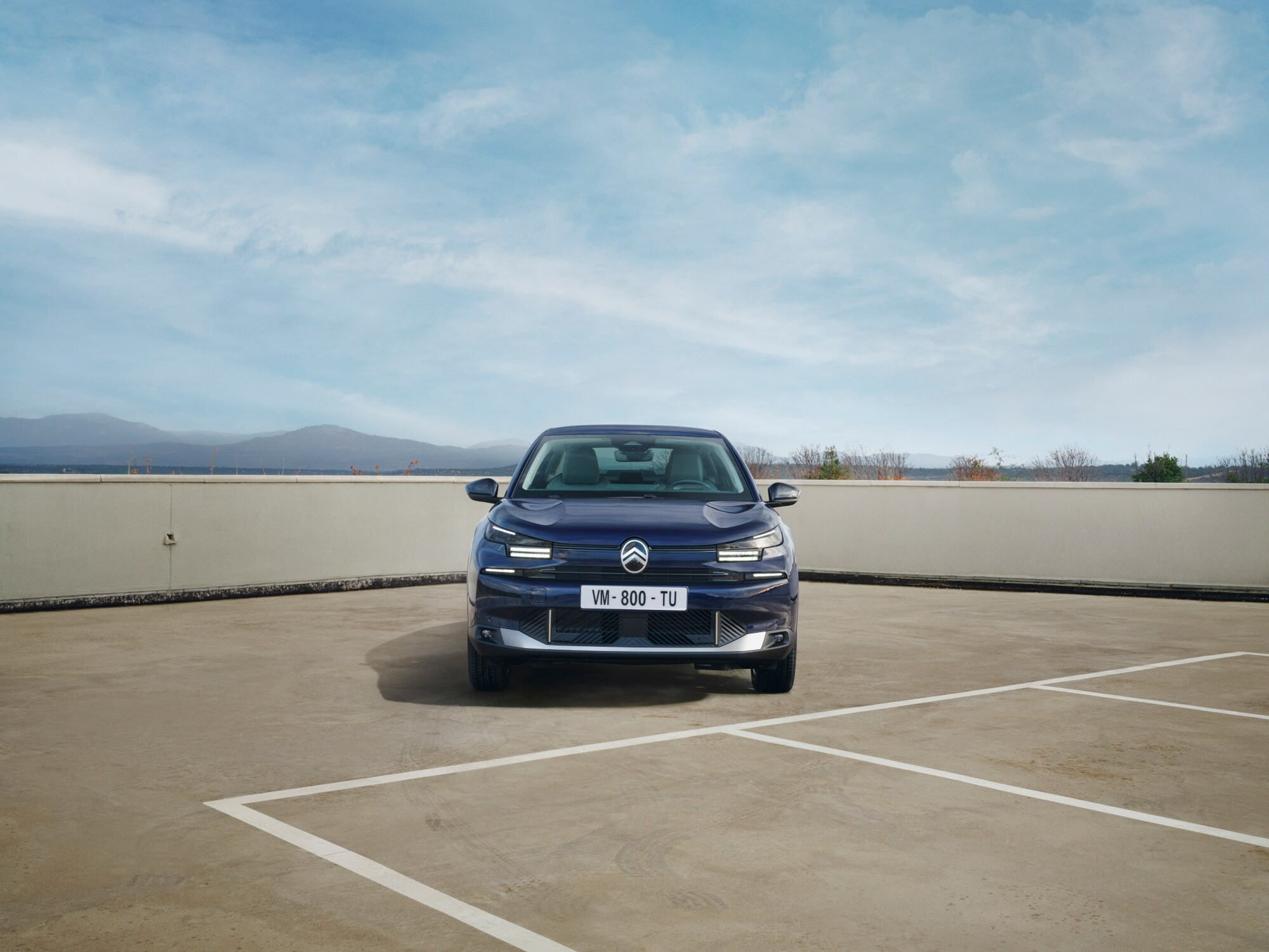 Vooraanzicht van de Citroën ë‑C4 X op een dakterrein met een krachtige fastback‑houding voor zelfverzekerde en betaalbare mobiliteit.