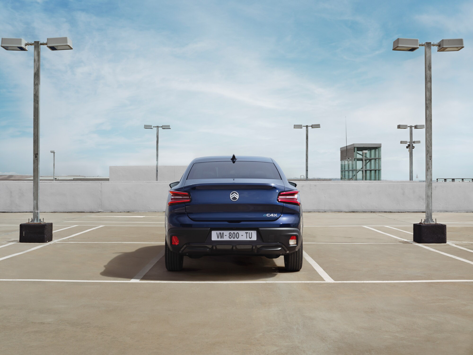 Achteraanzicht van de Citroën ë‑C4 X op een dakterrein met een onderscheidend fastback‑design voor stijlvolle en betaalbare mobiliteit.